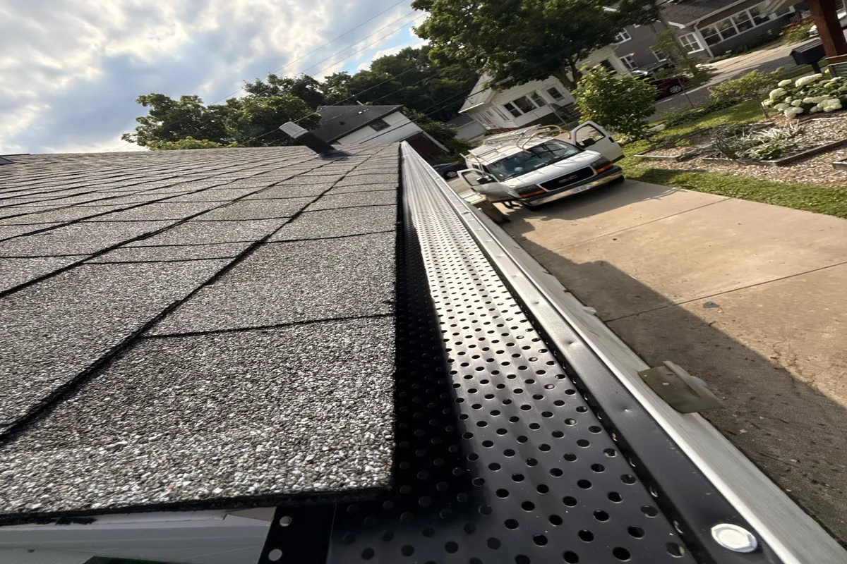 Metal gutters installed next to new shingle roof on a Madison home